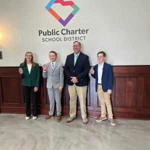 Landon Satterfield, Abraham Fuller, Addison Moss with Superintendent Neeley Holding Challenge Coins
